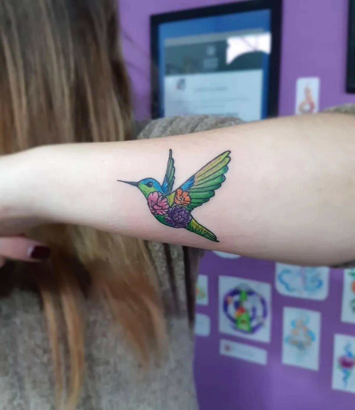 kolibri als tattoo am unterarm farbig bunt