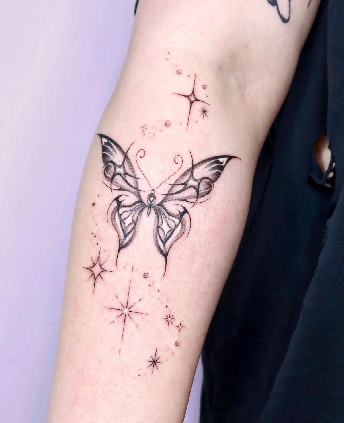 unterarm tattoo großer schmetterling mit kleinen sternen