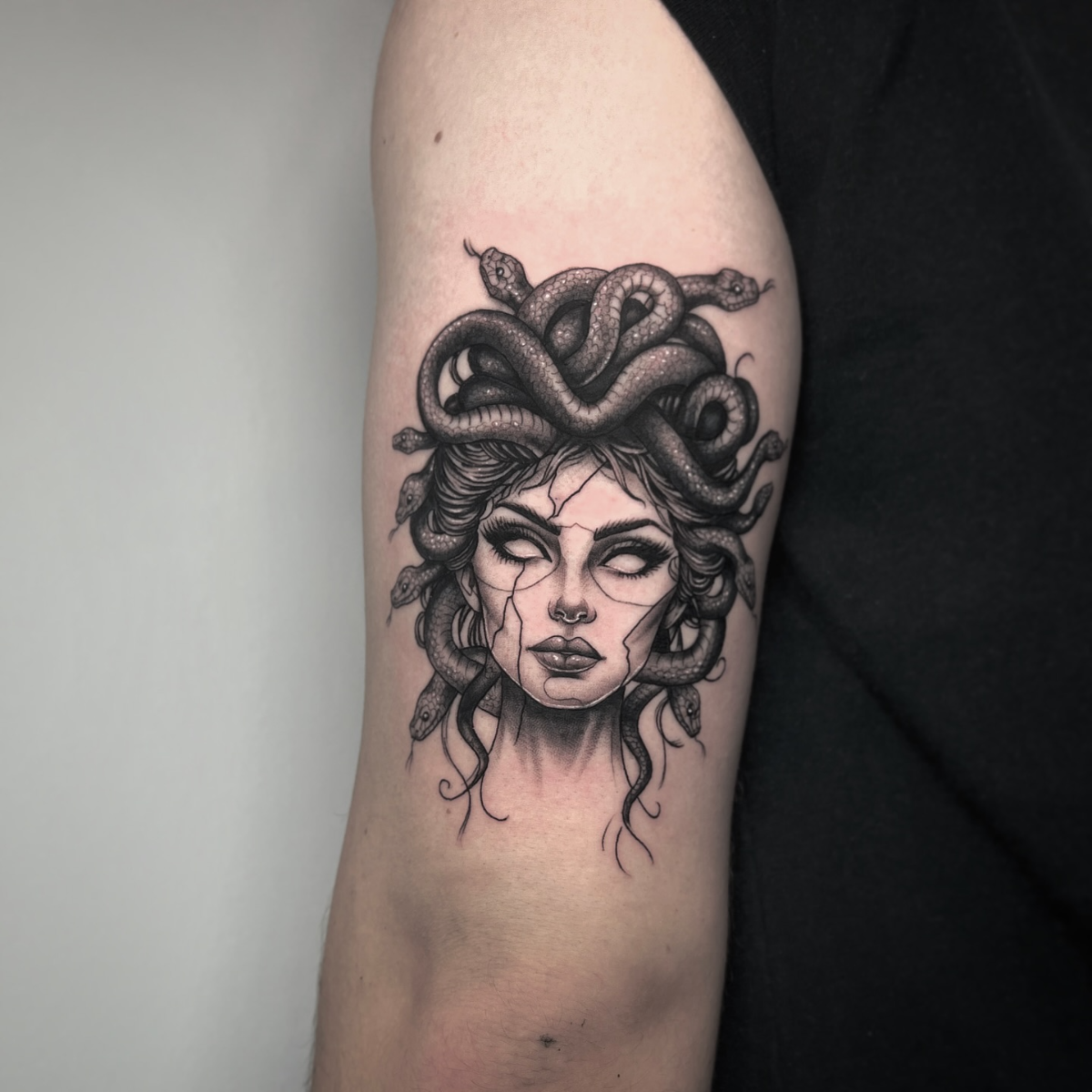 schwarzes und graues medusa tattoo auf dem arm