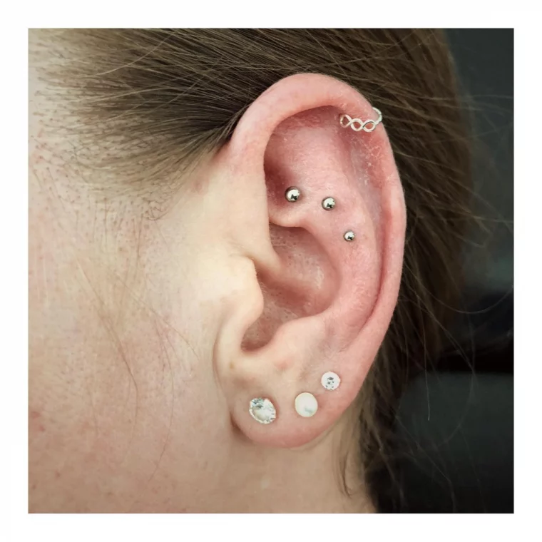 ein paar kleine piercings am ohr einer frau