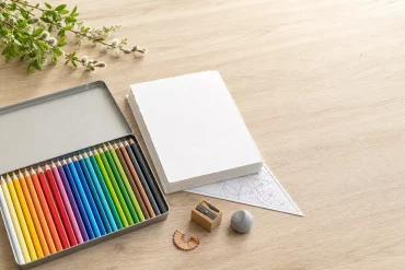 Buntstifte, Zeichenkarton und Spitzer als Material-Flatlay für Osterbilder