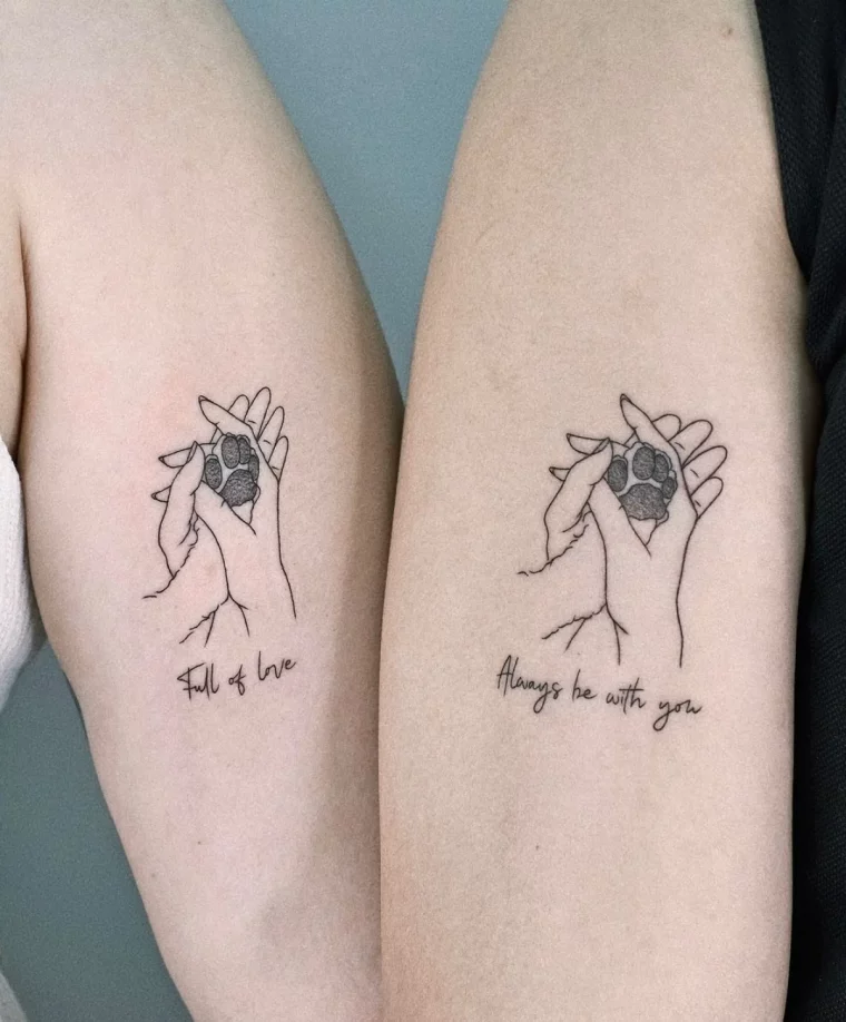 paar tattoos am oberarm zwei hände und pfote