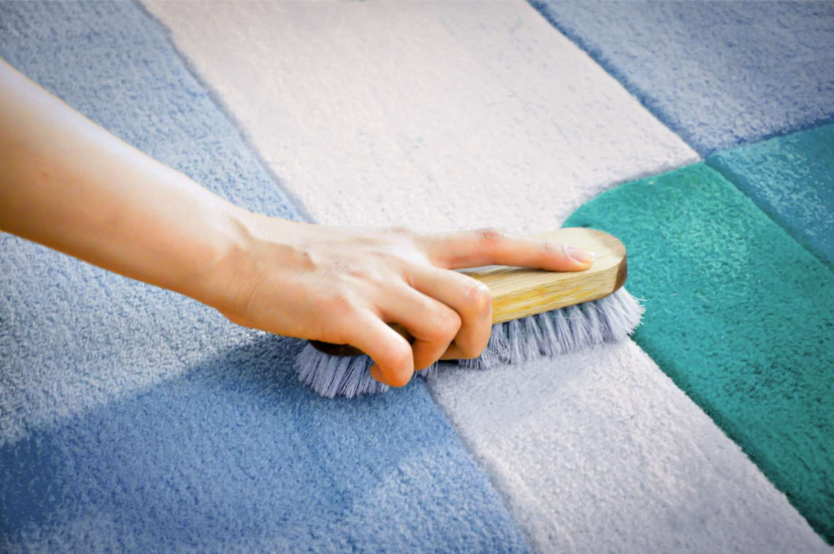 blauer teppich mit blauer bürste reinigen