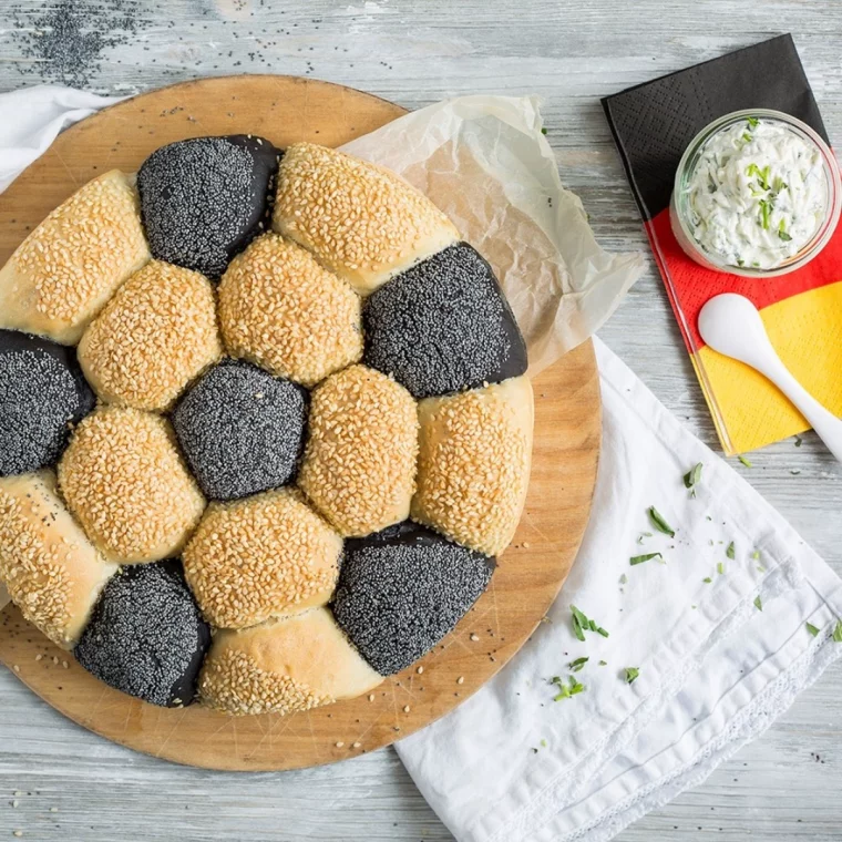 brot in form eines fußballs neben der deutschen flagge