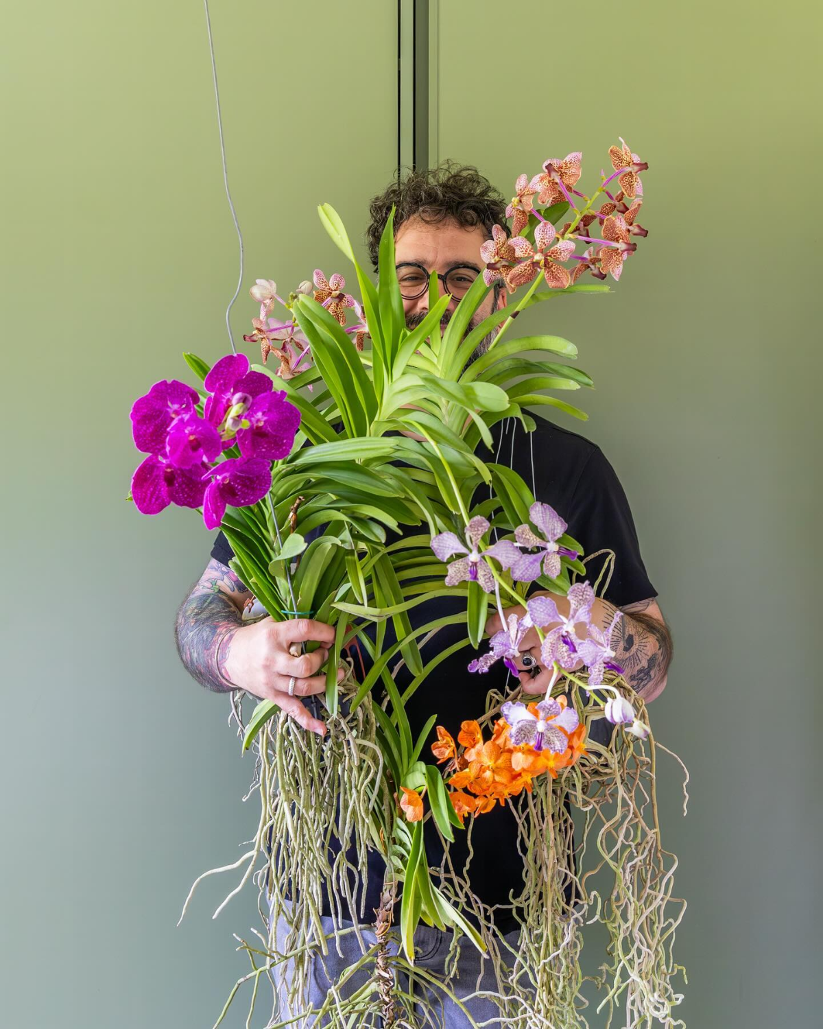 mann hält eine menge orchideen
