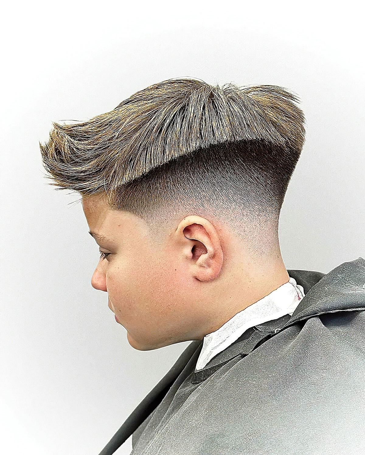 haarschnitt jungs fade schnitt mit langem blonden deckhaar 2024 vadim shifrin barber