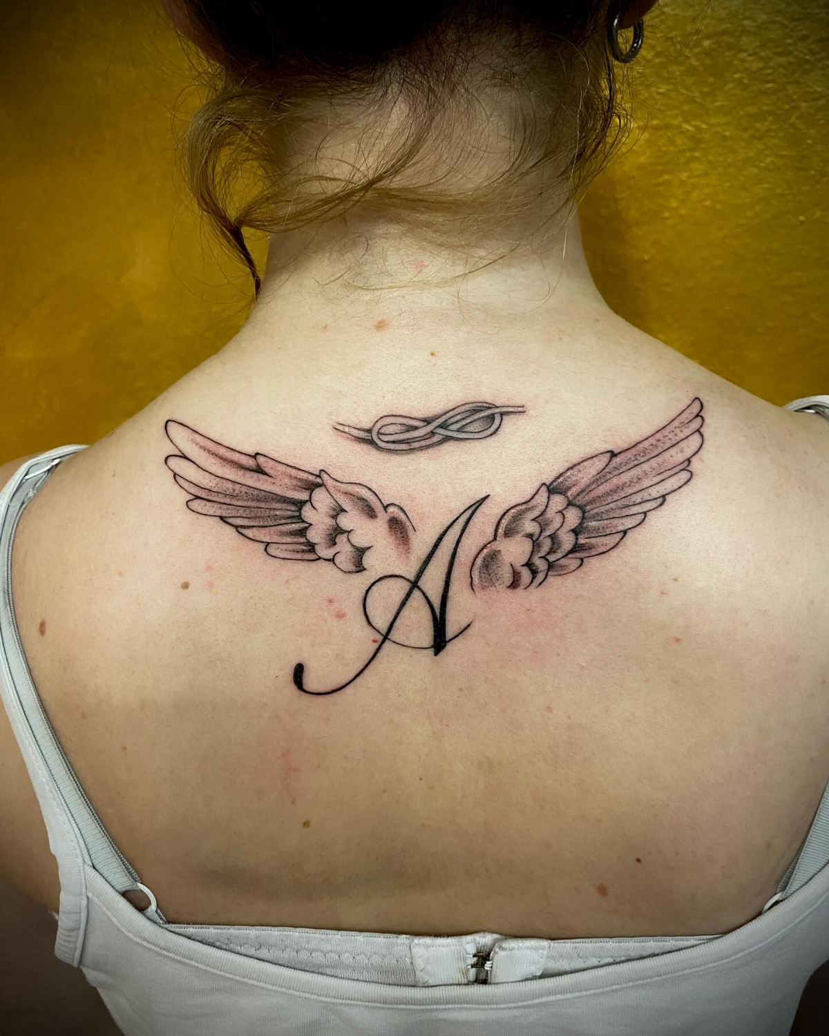 flügel mit initialen tattoo