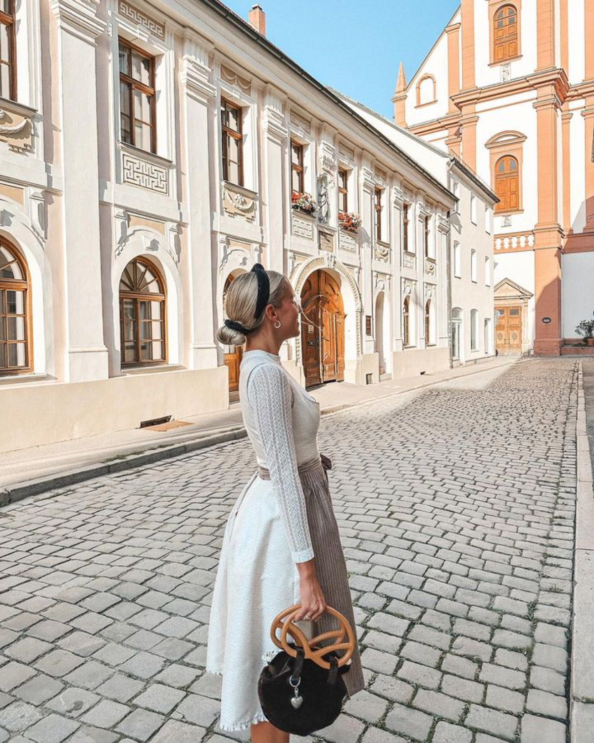 frau mit trendigem oktoberfest outfit und tasche als brezel