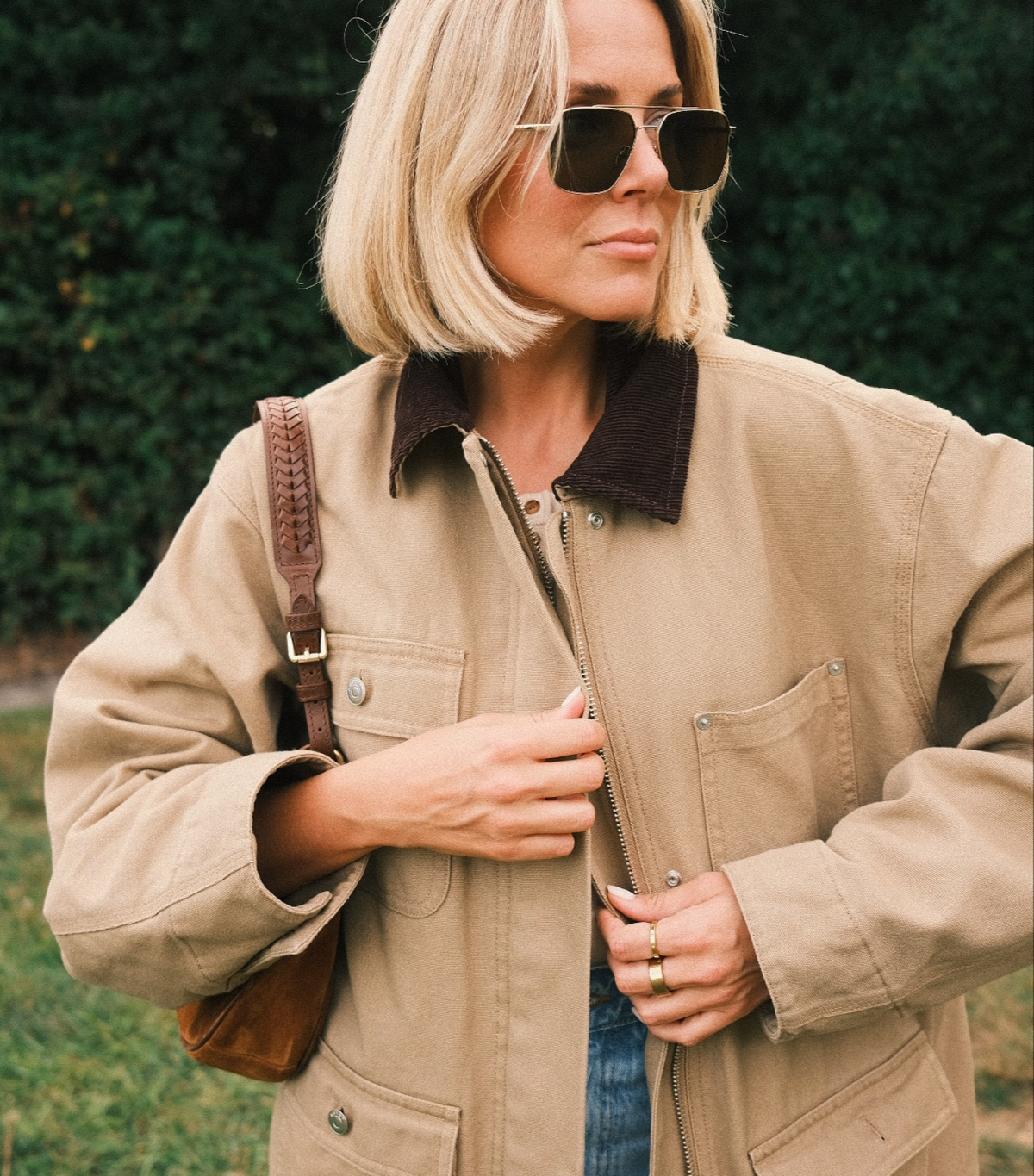 frau mit trendiger sonnenbrille, trendiger jacke und blonden haaren