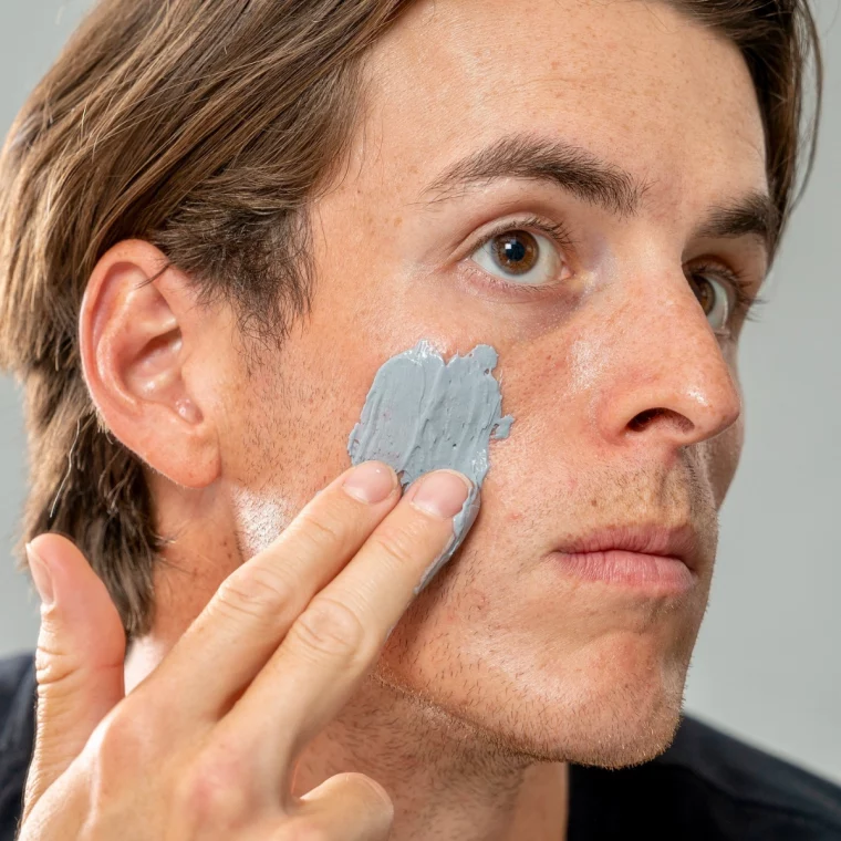 mann trägt maske auf sein gesicht auf