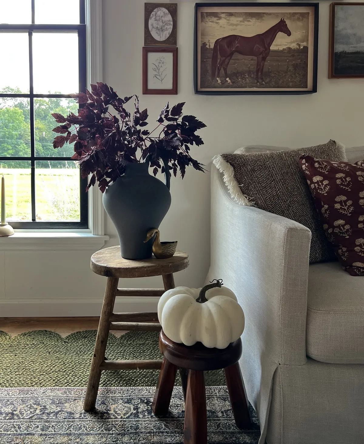 herbstliche akzente im wohnzimmer großer weißer kürbis auf hocker