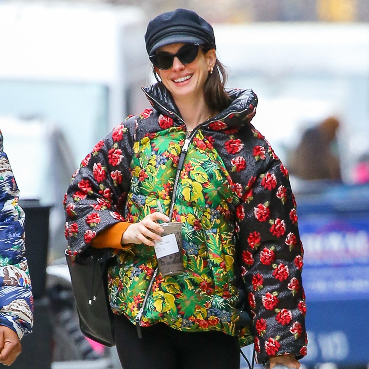 anne hathaway trägt eine bunte daunenjacke