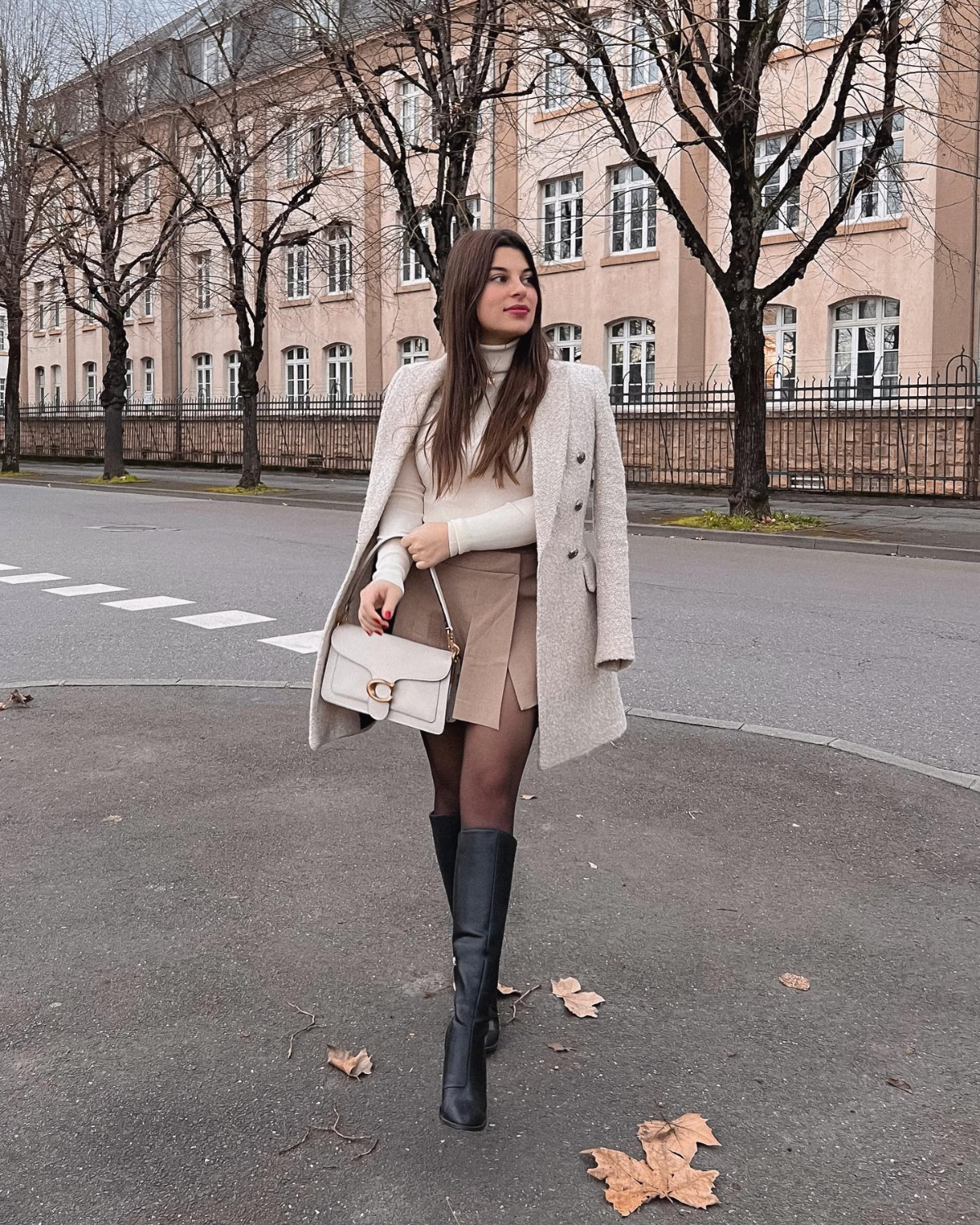 frau mit sexy winteroutfit mit stiefeln und kurzem rock