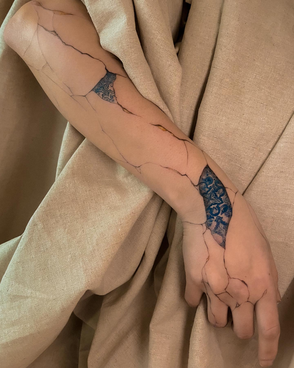 kintsugi tattoo auf dem arm einer frau