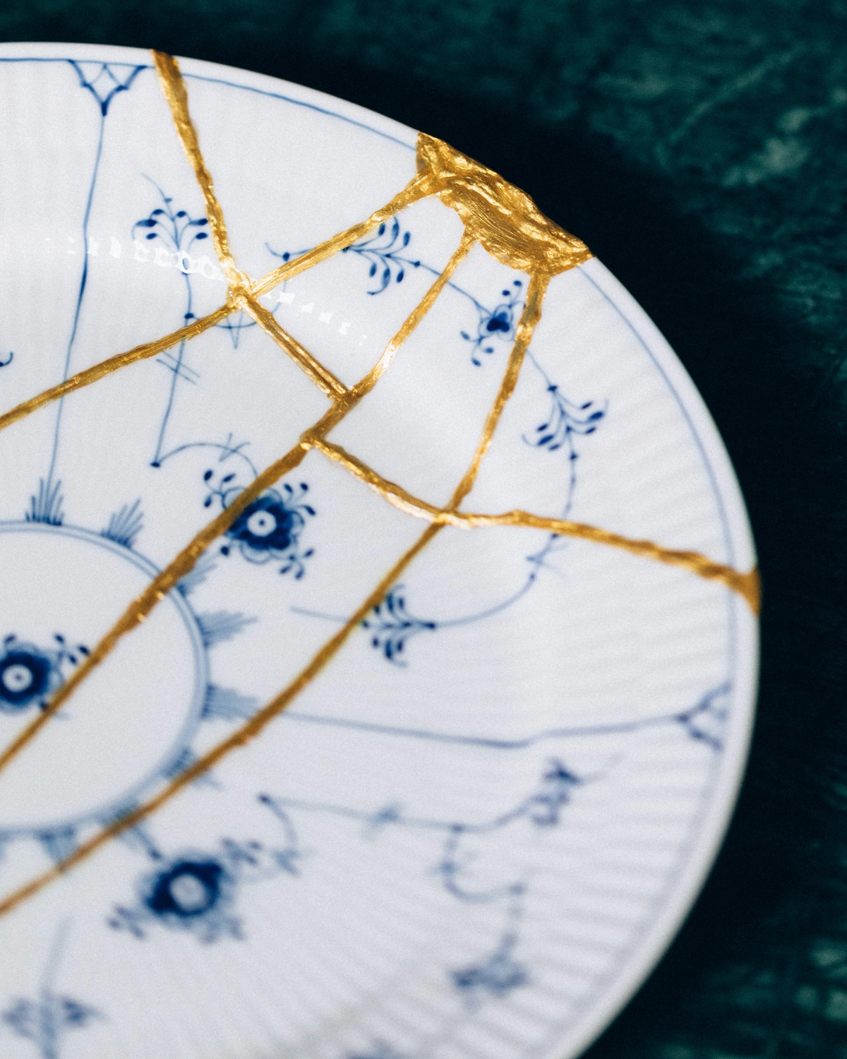 teller mit goldenem kintsugi und blauen details