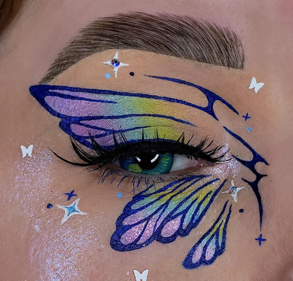 augen make up mit schmetterling flügel in regenbogenfarben