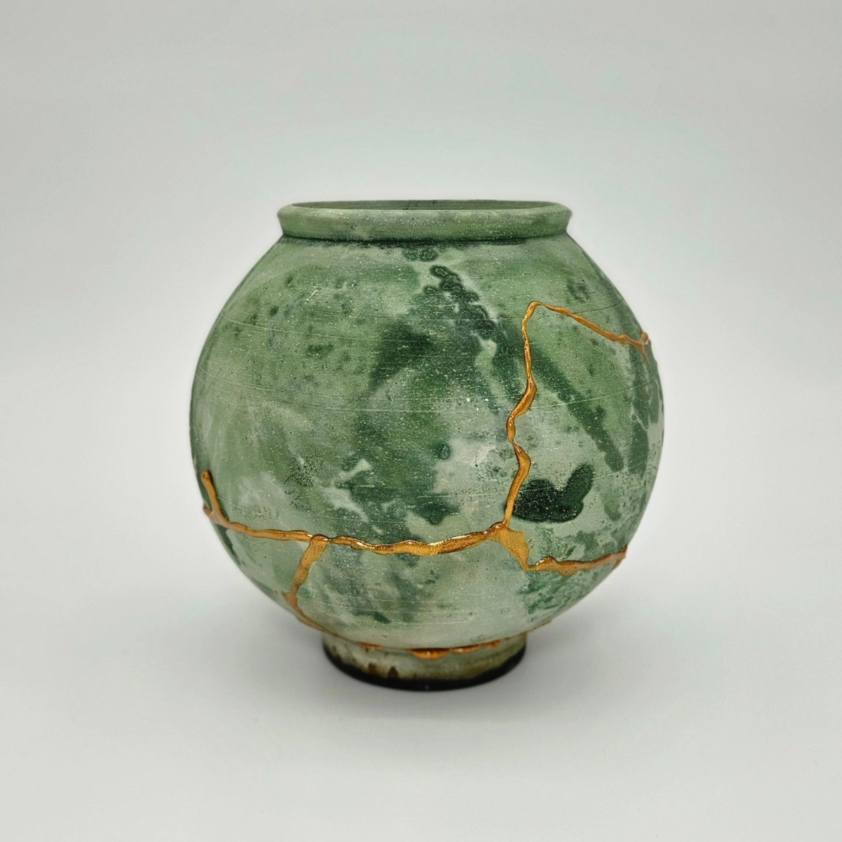 grüne vase mit goldener kintsugi technik