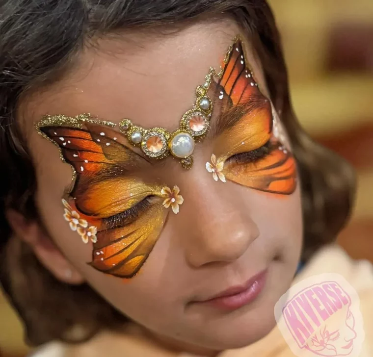 kind als schmetterling schminken orange und gelbtöne mit strasssteinen und perlen