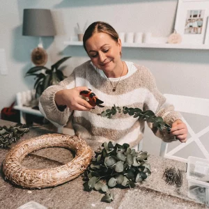 frau, die selbst adventskranz bastelt