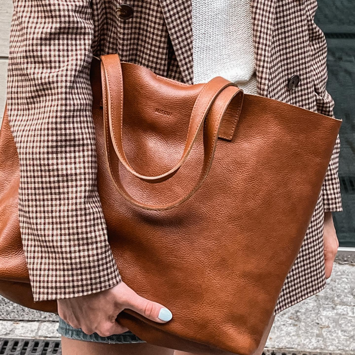 frau mit blazer und tasche in cognac farbe