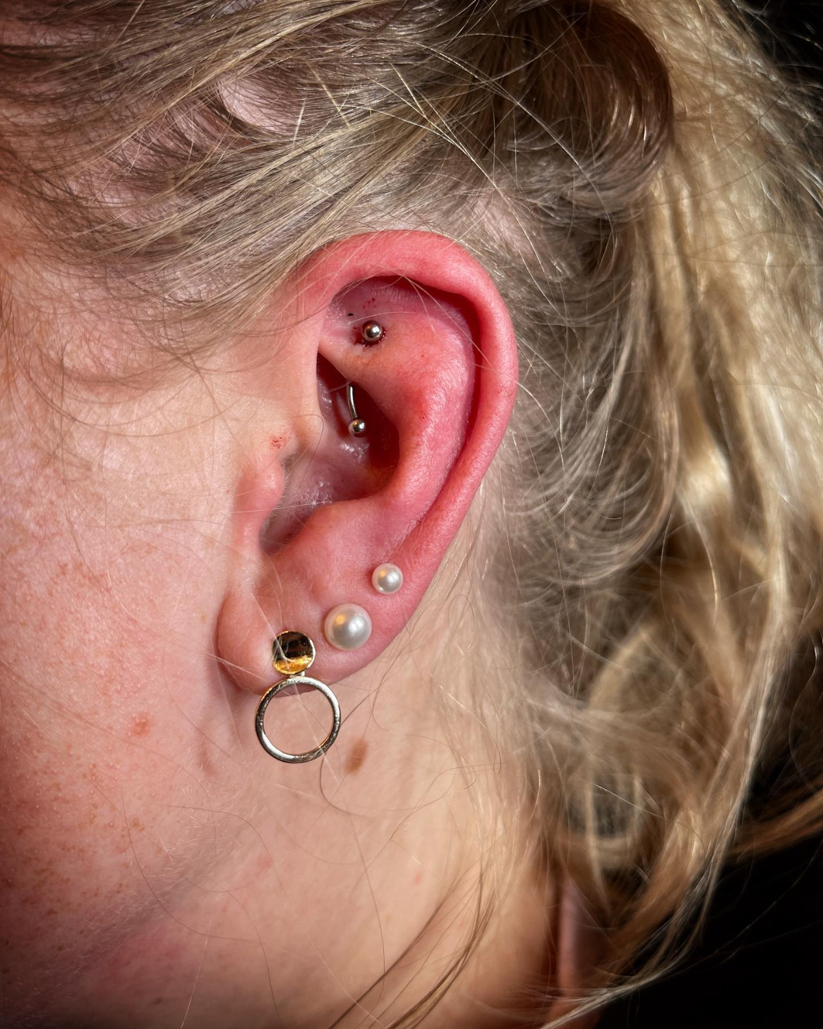 frau mit blonden haaren und einem rook piercing