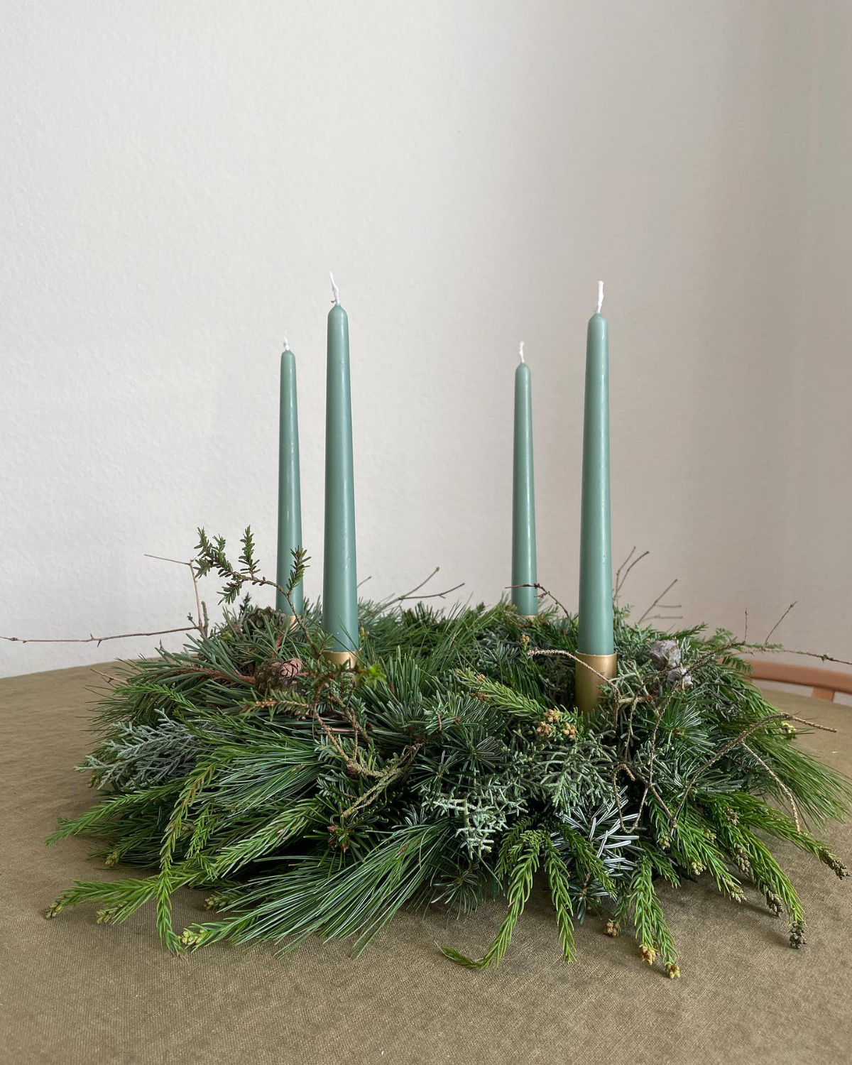 frischer grüner adventskranz mit grünen kerzen