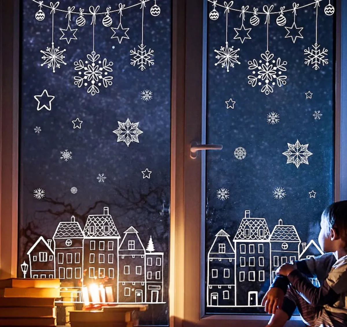 fensterdeko für weihnachten mit kreidestift schneeflocken und häuschen