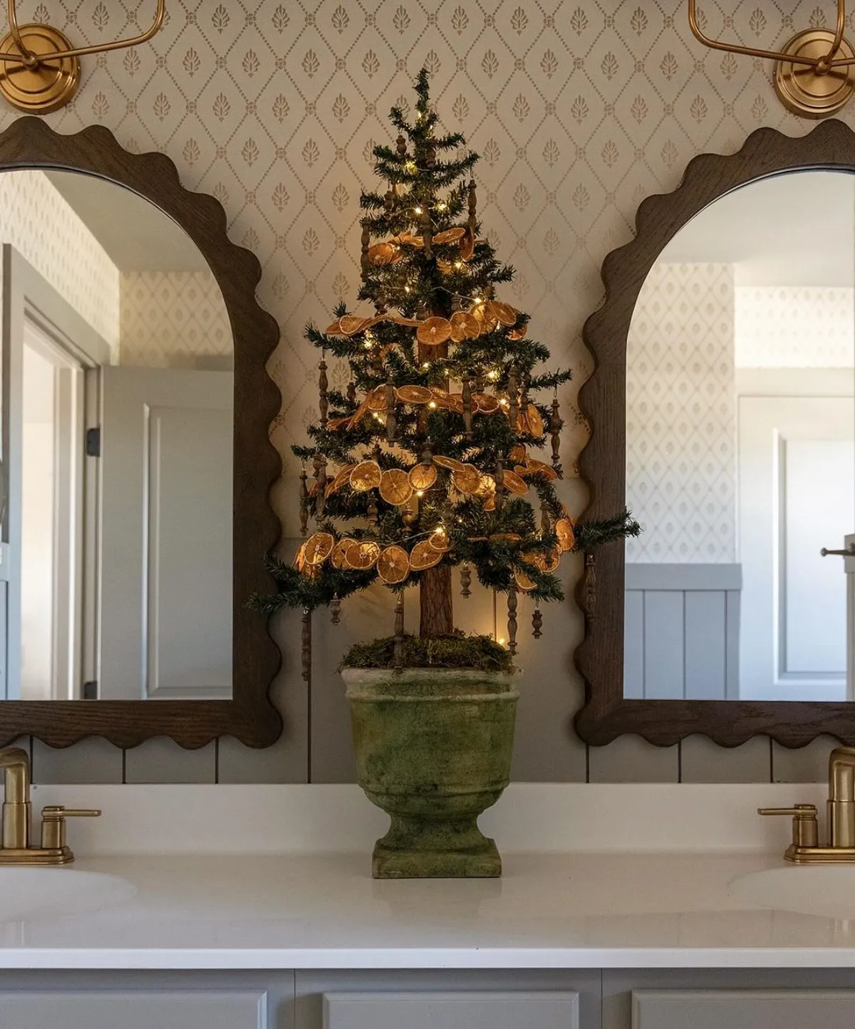 kleiner christbaum geschmückt mit getrockneten orangenscheiben