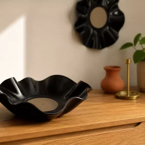 Gewellte dunkle Vinylschale als Deko aus Schallplatten auf Eichensideboard