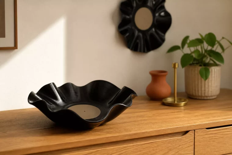 Gewellte dunkle Vinylschale als Deko aus Schallplatten auf Eichensideboard