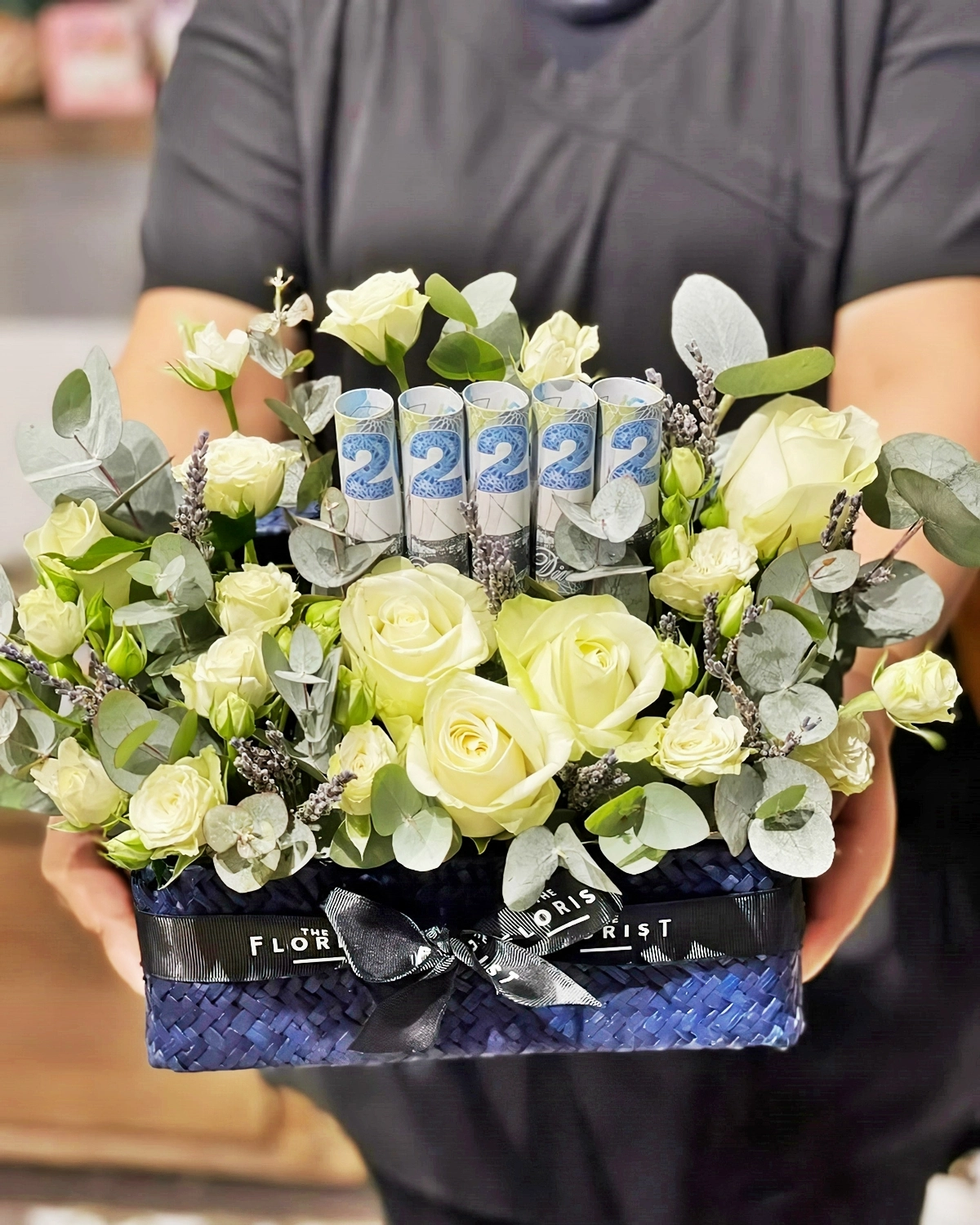 geldgeschenk verpacken ideen schachtel mit blumen und gerollten banknoten theflorist kw