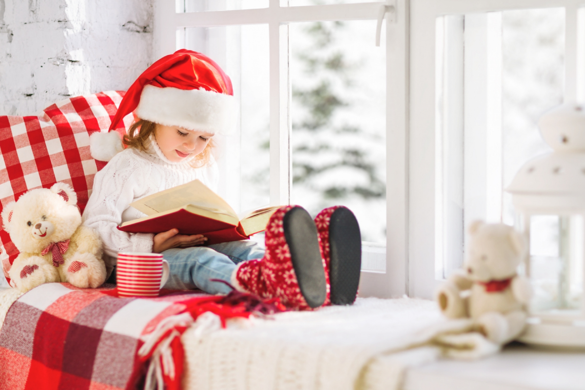 kleines mädchen liest weihnachtsgeschichten