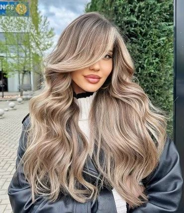 frisuren mit schraegem pony lange wellige haare balayage blonde strahnen grosser seitlicher pony mastersofbalayage