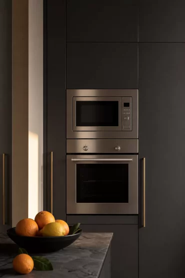 Anthrazitfarbene Küche mit Backofen und Mikrowelle im Hochschrank