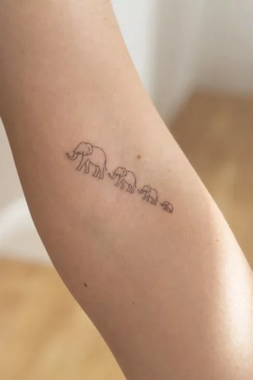 Elefantenfamilie als kleines Symbol-Tattoo am Unterarm