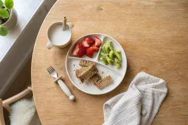 Kindgerechtes Frühstück gedeckt auf kleinem Holztisch