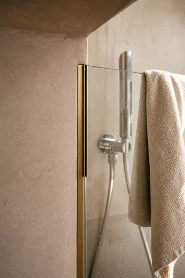 Übergang von Mauerwerk zu Glas in einer begehbaren Dusche