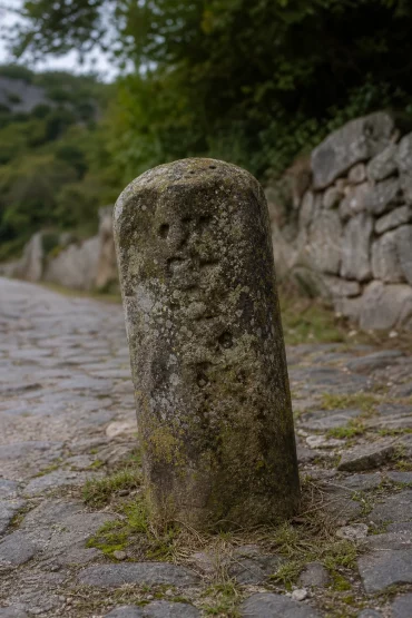 Alter Meilenstein aus Naturstein am Rand einer Römerstraße