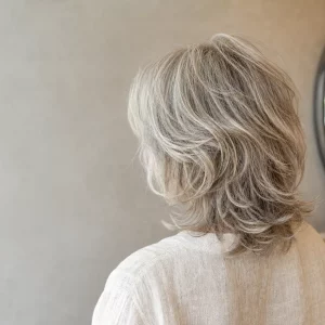 Mittellange Frisur ab 50 mit weichen Stufen in Silberblond
