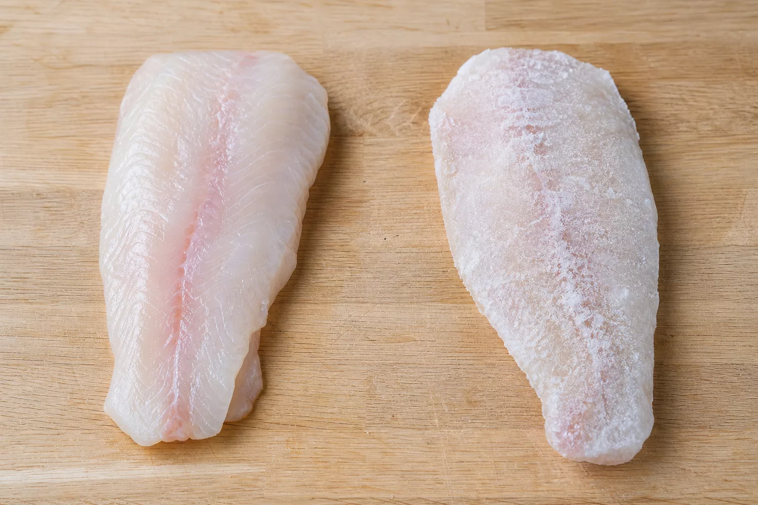 Frisches und tiefgefrorenes Pangasiusfilet nebeneinander