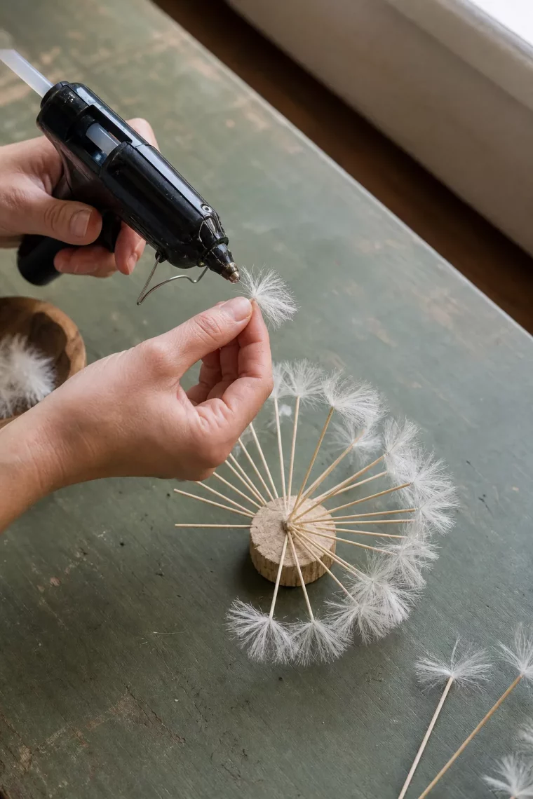 Hände befestigen weißes Bastelmaterial für die Pusteblume
