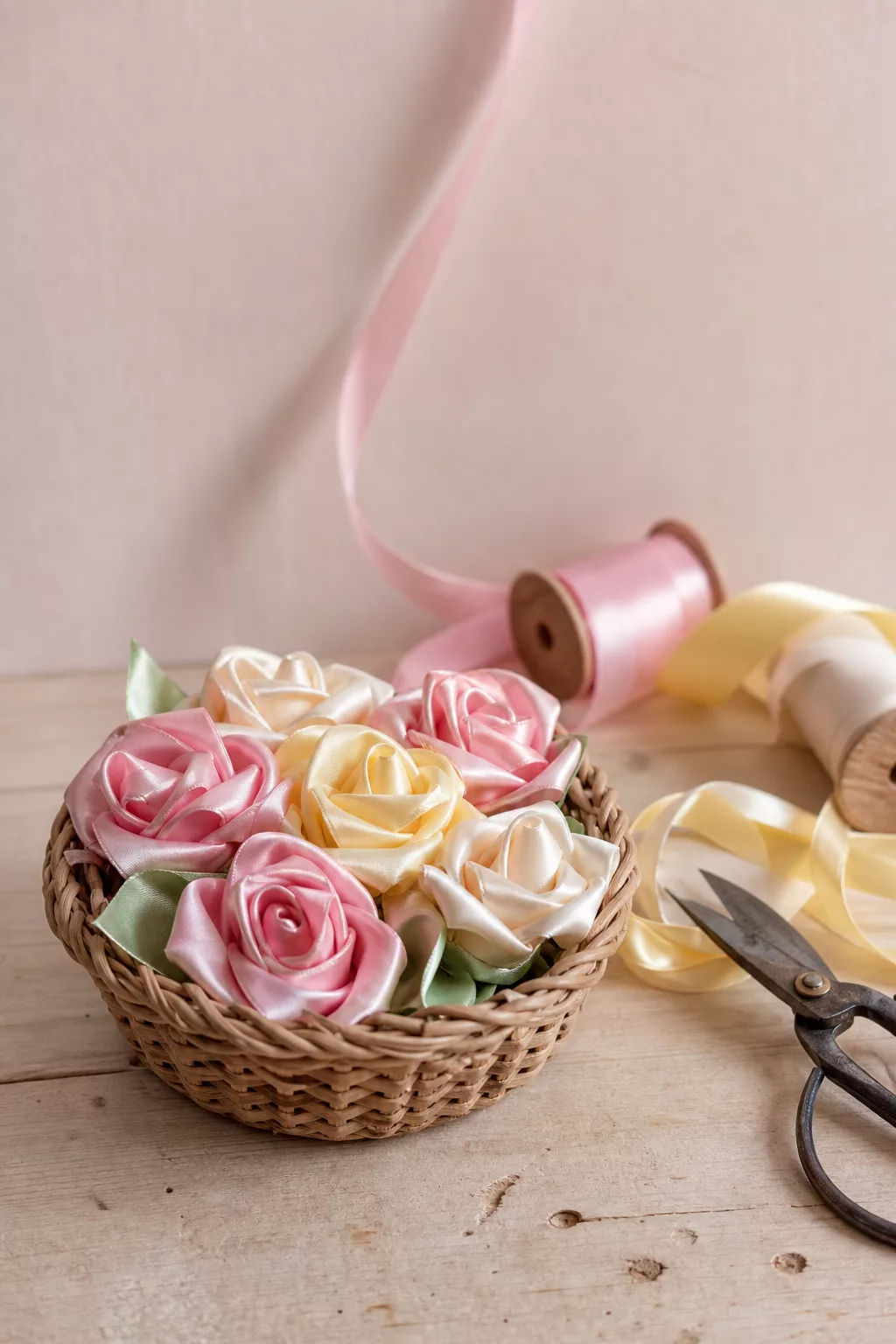 Selbstgebastelte Rosen aus Satinband in kleinem Weidenkorb