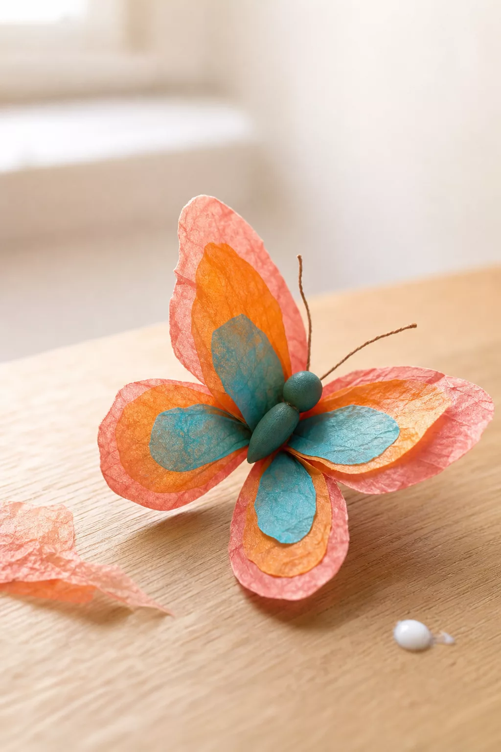 Detailaufnahme eines gebastelten Schmetterlings aus buntem Transparentpapier