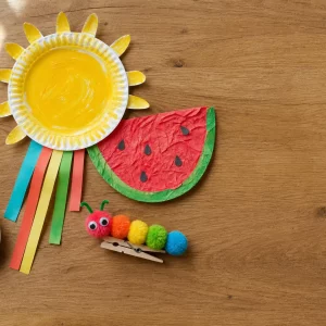 Bunte Sommer-Bastelideen für 2-jährige Kinder auf Holztisch drapiert