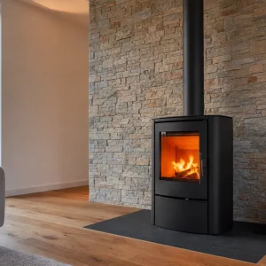 Moderne Steinwand mit Riemchen hinter schwarzem Kaminofen im Wohnzimmer