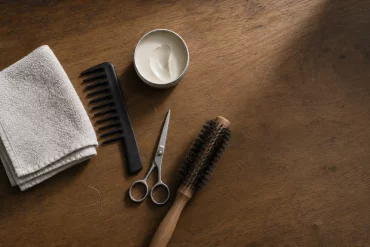 Flatlay mit Kamm, Schere und Haarwachs für Kinderfrisuren