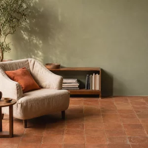 Wandfarbe Salbeigrün kombiniert mit warmen Terracotta Fliesen im Wohnzimmer