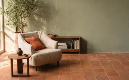 Wandfarbe Salbeigrün kombiniert mit warmen Terracotta Fliesen im Wohnzimmer