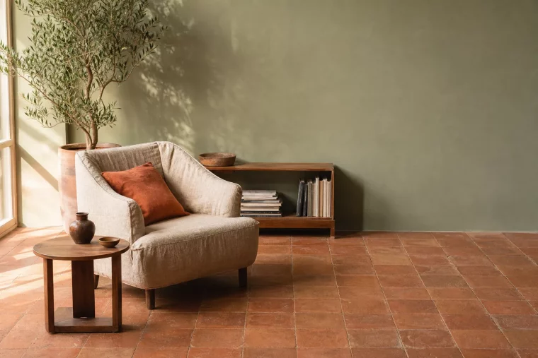 Wandfarbe Salbeigrün kombiniert mit warmen Terracotta Fliesen im Wohnzimmer