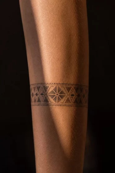 Geometrisches Dotwork-Tattoo als Band um den Unterarm